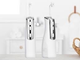 Two Miracle Smile water flosser handles standing on a bathroom shelf